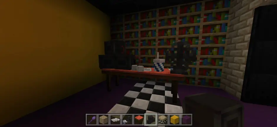 Небольшой стол с элементами декора на фоне книжных полок