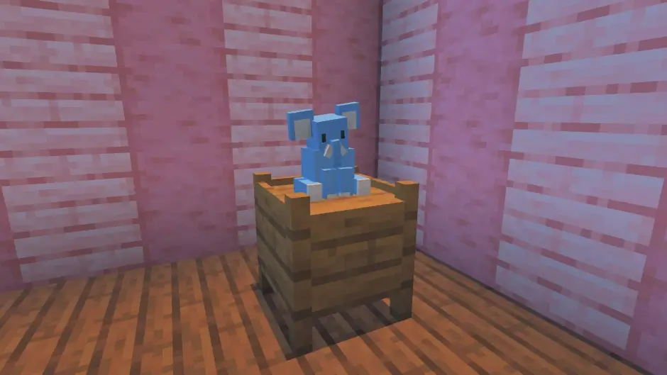 Плюшевый слон сидит на фоне розовой стены